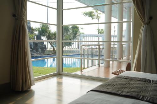 1 dormitorio con ventana grande con vistas a la piscina en Hà Phương Homestay, en Lang Co