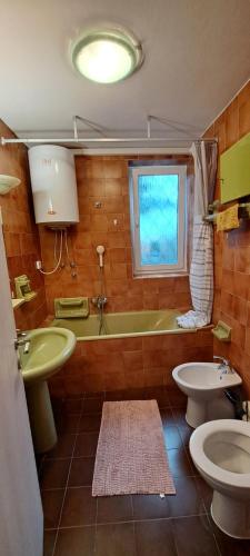 a bathroom with two toilets and a tub and a sink at Apartma Rian in Koper