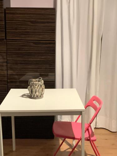 a table with a bowl and a pink chair at Casa Turchina in Vernante