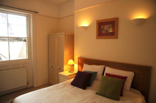 a bedroom with a bed with pillows and a window at Brunswick Family Sea View Apartment in Brighton & Hove