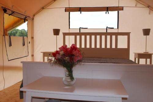um vaso de flores sobre uma mesa numa tenda em Glempings Janavas 