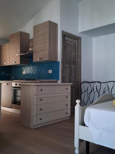 una cucina con armadi in legno e un letto in una camera di Relax al Mare a Olbia