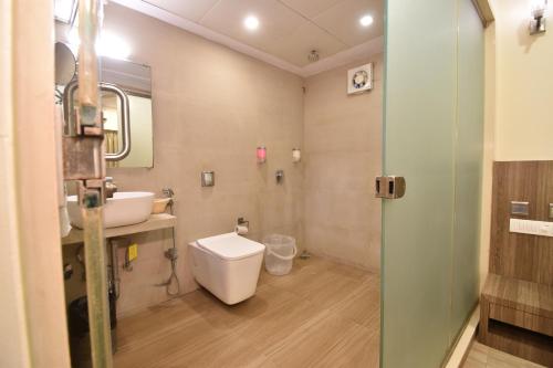 a bathroom with a toilet and a sink and a mirror at Hotel Atlantic in Mumbai