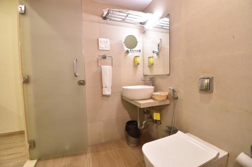 a bathroom with a sink and a toilet and a mirror at Hotel Atlantic in Mumbai