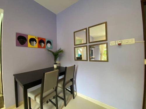 a dining room with a table and two mirrors at Pali Carters Building 101, 20th Road, Khar West by Connekt Homes in Mumbai