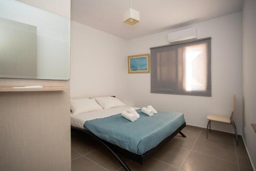 a bedroom with a bed with two towels on it at Costas Apartments in Polis Chrysochous
