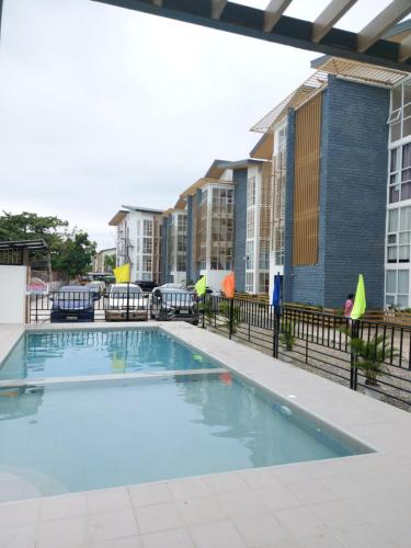 a swimming pool at a apartment complex with buildings at Fully Furnished Staycation - Neflix, Pool,Can cook near Mactan Airport in Maribago
