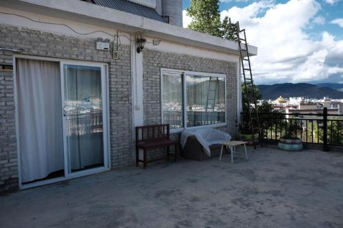a patio with a table and a chair and windows at Kevin's Trekker Inn in Shangri-La