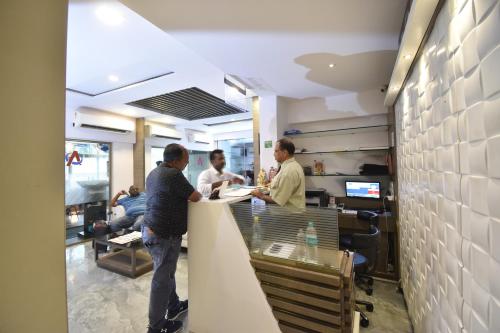 a group of men standing at a counter in an office at Hotel Atlantic in Mumbai