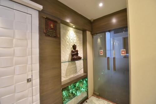 a room with a glass door with a statue on a shelf at Hotel Atlantic in Mumbai