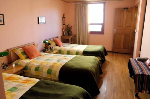 a hotel room with three beds and a window at Kevin's Trekker Inn in Shangri-La
