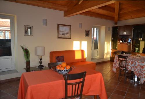 sala de estar con sofá naranja y mesa en Casa Fortunato, en Naso