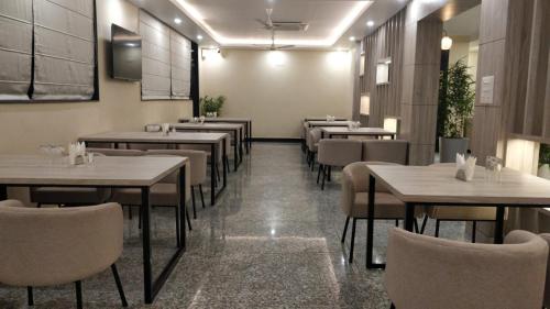 a restaurant with tables and chairs in a room at Green Icon Hotels & Resorts in Kandogal