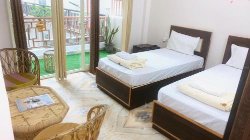 um quarto com duas camas e uma cadeira e uma janela em Rudram Hotel Yoga & Ayurveda Retreat em Rishikesh