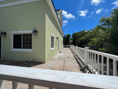 a porch of a house with a white fence at Hidden Gem Exuma - KING BED master suite and central air in Georgetown