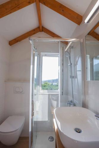 a bathroom with a white sink and a toilet at Villa Sole with Private Pool in Kaštela
