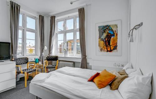 um quarto com uma cama branca e uma televisão em Villa Gertrud em Kolding