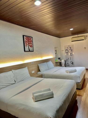 two beds in a hotel room with two beds sidx sidx sidx at Kangar Hotel Sdn Bhd in Kangar
