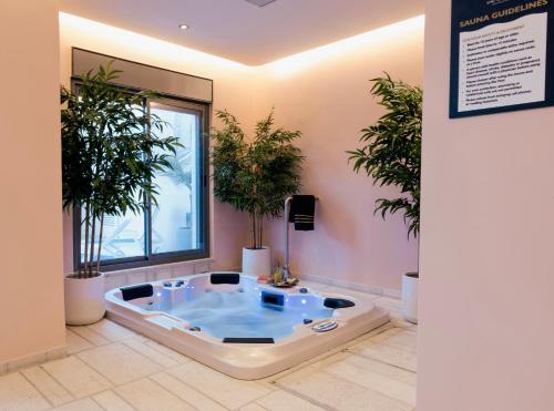 a jacuzzi tub in a room with potted plants at Dar Al Mauge Boutique Hotel with Outdoor Pool in Bethlehem
