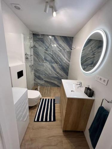 a bathroom with a sink and a toilet and a mirror at Apartment Jane Malibu Park in Adeje
