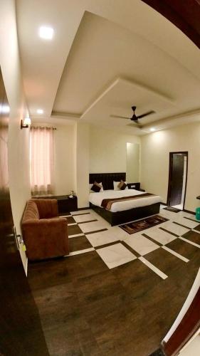 a large bedroom with a bed and a couch at Hotel Govindam Elite in Juhi Bari