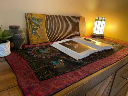 a book sitting on top of a table with a lamp at The Groves at Redway Beach - Studio in Redway