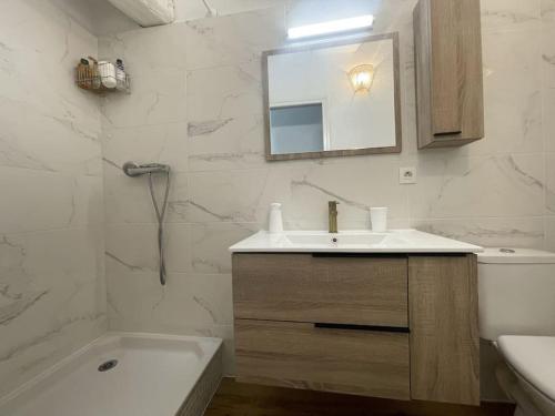 une salle de bain avec un lavabo, des toilettes et un miroir dans l'établissement Charmante maison au village, à Gruissan
