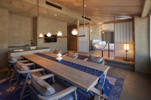 a dining room with a table and chairs and a bed at THE HOTEL HIGASHIYAMA KYOTO TOKYU, A Pan Pacific Hotel in Kyoto