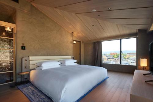a bedroom with a large white bed and a large window at THE HOTEL HIGASHIYAMA KYOTO TOKYU, A Pan Pacific Hotel in Kyoto