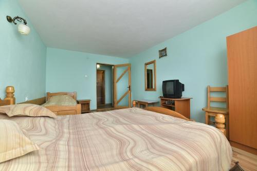 1 dormitorio con 1 cama grande y TV en La Mitica, en Ranca