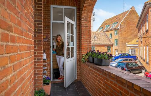 a woman standing in the doorway of a brick building at Villa Gertrud - Bed & Breakfast in Kolding