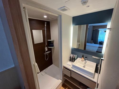 a bathroom with a sink and a mirror at Shogetsu Grand Hotel in Jozankei
