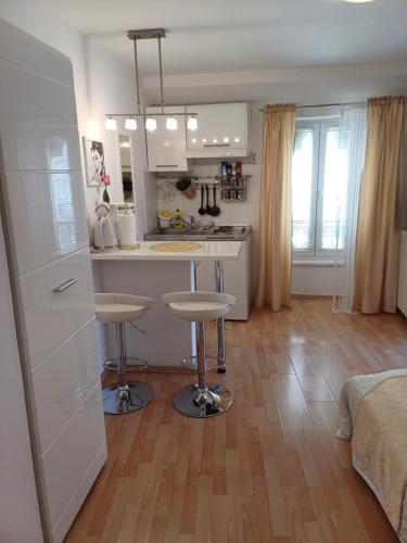 uma cozinha com um balcão e dois bancos num quarto em Private Apartments In Diocletians Palace em Split