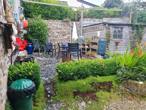 a garden with chairs and plants in a yard at Anvil House, The Old Forge in Saint Erth