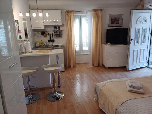 a bedroom with a bed and a kitchen with a counter at Private Apartments In Diocletians Palace in Split