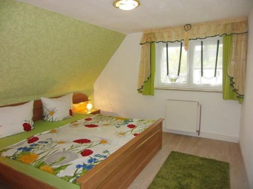 um quarto com uma cama e uma janela em Ferienwohnung-Ritscher-in-Lichtenhain-1 em Lichtenhain