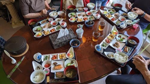 a group of people sitting around a table with food at Pension Alba - Vacation STAY 70925v in Tateyama