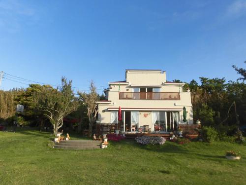 a large white house on a green lawn at Pension Alba - Vacation STAY 70925v in Tateyama