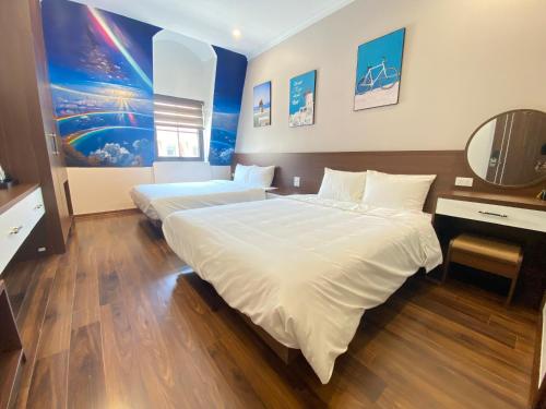 a hotel room with two beds and a mirror at MOONLIGHT HOTEL in Ha Long