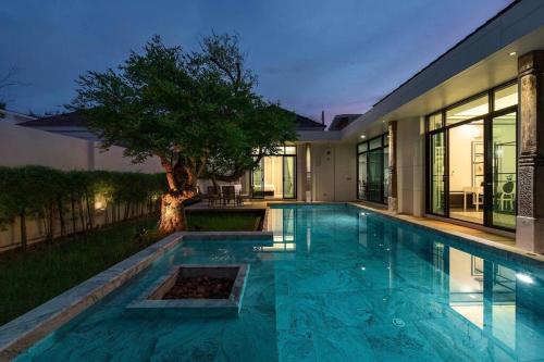 a swimming pool in front of a house at Full Moon现代豪华三卧室泳池别墅 查龙海滩 500 米 查龙码头 普吉大佛 拉威海鲜 in Chalong 