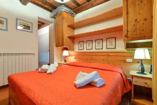 um quarto com uma cama vermelha e toalhas em 42- Casetta Benetollo Vacanza in Toscana - CASA PRIVATA em Castel del Piano