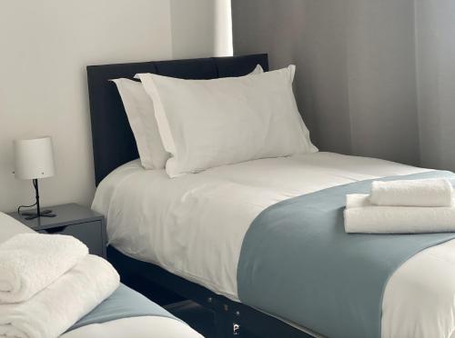a bedroom with a bed with two towels on it at Manhattan Pad in London