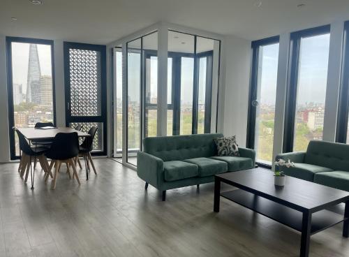 a living room with two couches and a table and a dining room at Manhattan Pad in London