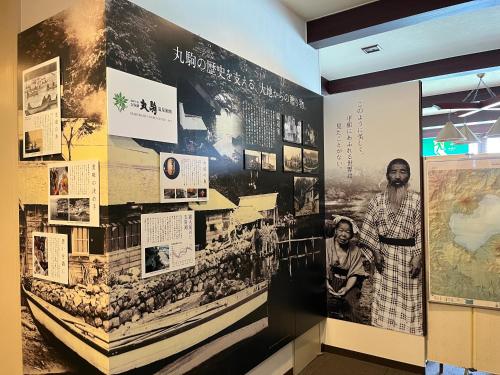 a wall with photographs and posters on it at Sapporo's Secret Onsen Sanctuary Marukoma Onsen Ryokan in Chitose