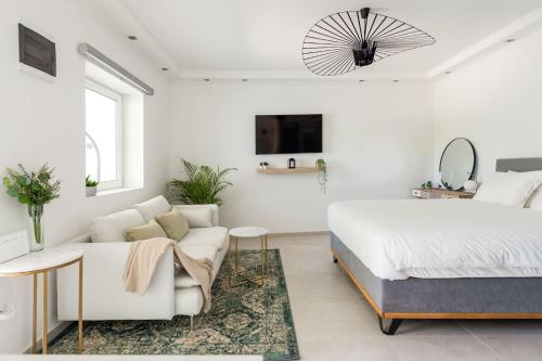 een witte slaapkamer met een bed en een bank bij New beautiful studio, private terrace-Hvar town in Hvar