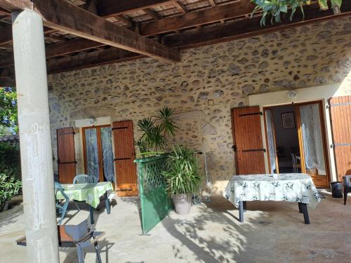 une terrasse d'une maison avec une table et des plantes dans l'établissement Gîte 4 