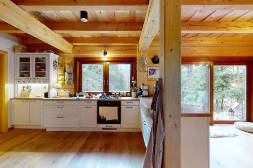 a kitchen with white appliances and wooden ceilings at Chata Vysoké Tatry in Stará Lesná