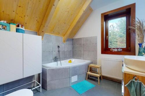 a large bathroom with a tub and a sink at Chata Vysoké Tatry in Stará Lesná