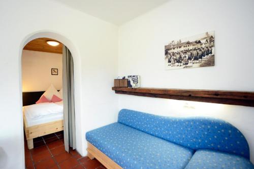 a blue couch in a room with a bed at Schmiedhof in Seefeld in Tirol