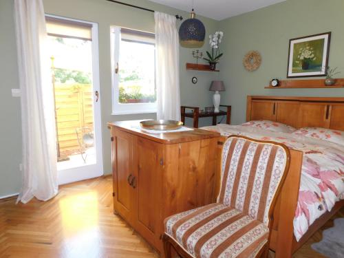 um quarto com uma cama, uma cadeira e uma janela em Vali's Paradise em Ptuj